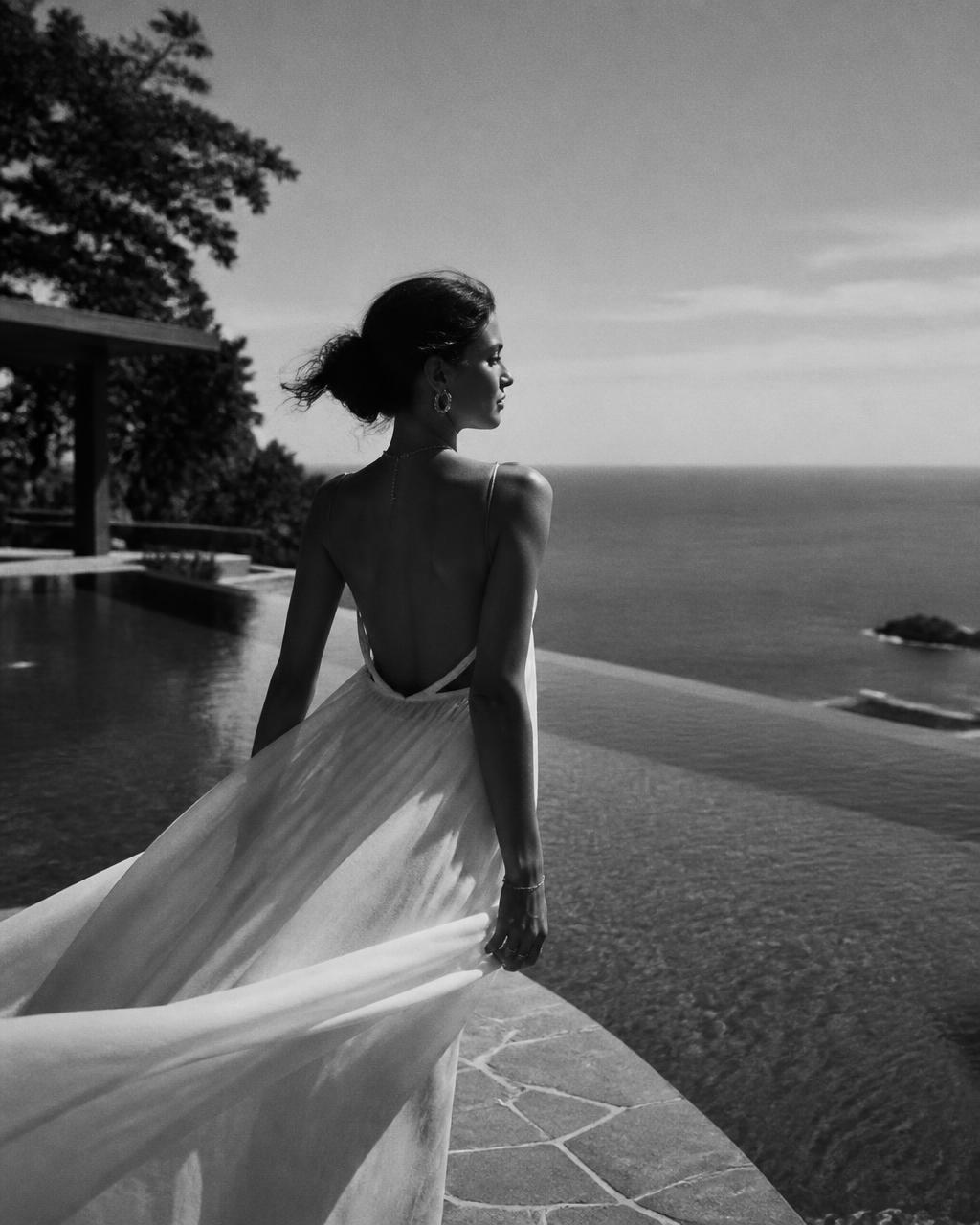 Woman by an infinity pool overlooking the ocean